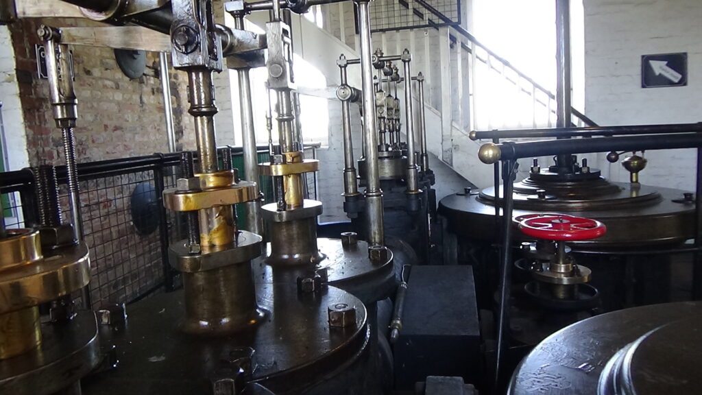 Room filled with metal parts made from brass and cast iron belonging to over 200 year old stationary steam engines